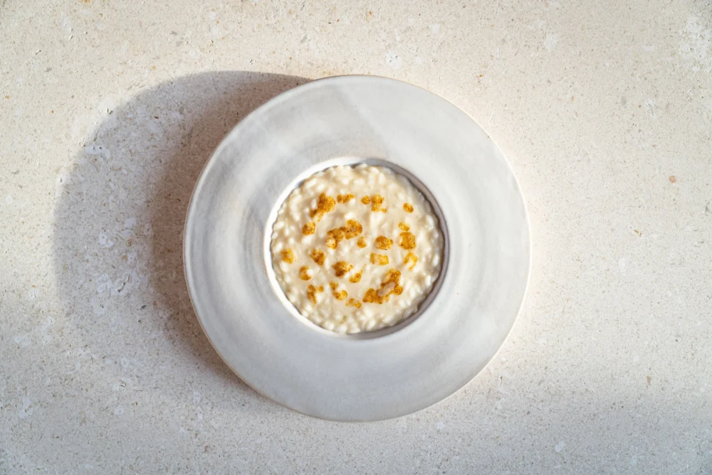 Close-up of a creamy risotto served on a white ceramic plate at Abba Milano.