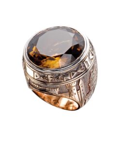 Close-up of the “Medioevo” men’s ring in rose gold with engraved motifs and a large round-cut cognac topaz.