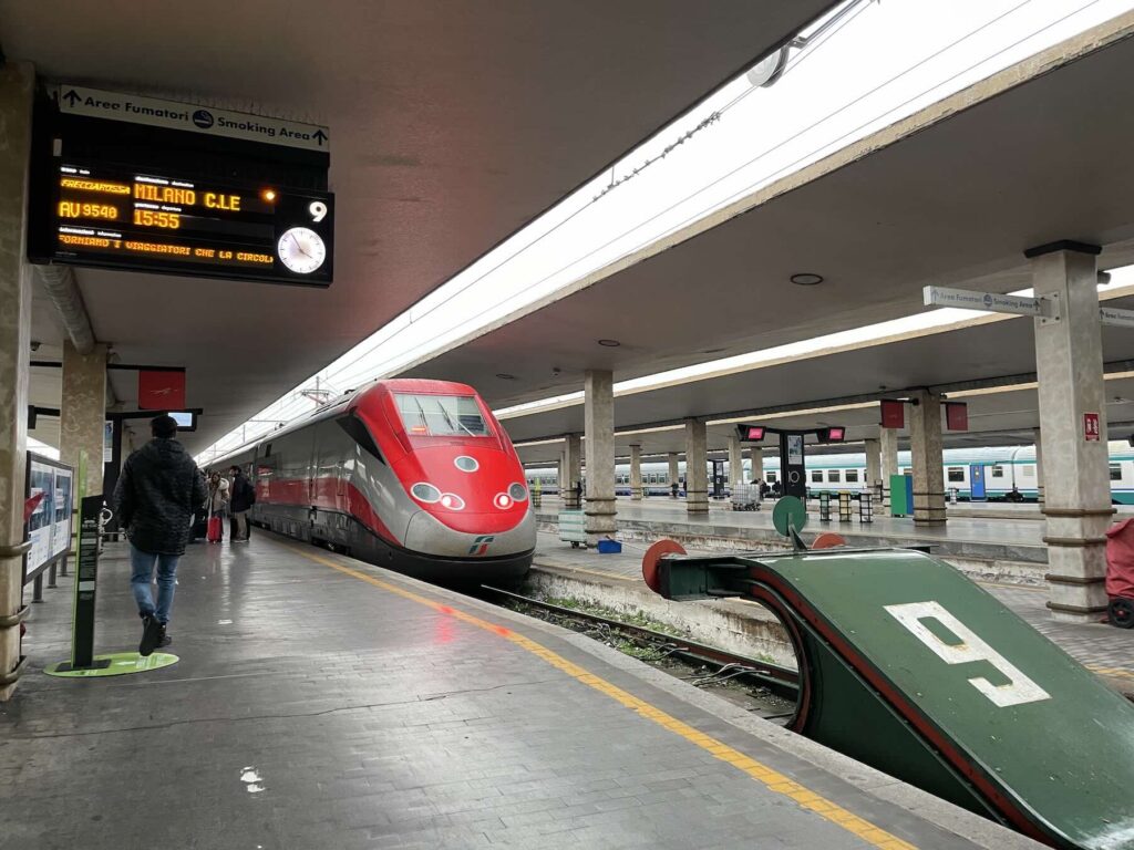 Trenitalia dynamic pricing 2026: what changes for high-speed train travel from Milan: Frecciarossa high-speed train stopped at the platform, with the departure board showing destination Milano Centrale.