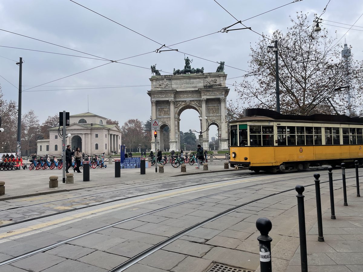 Classic yellow ATM tram passing in front of the Arco della Pace in Milan